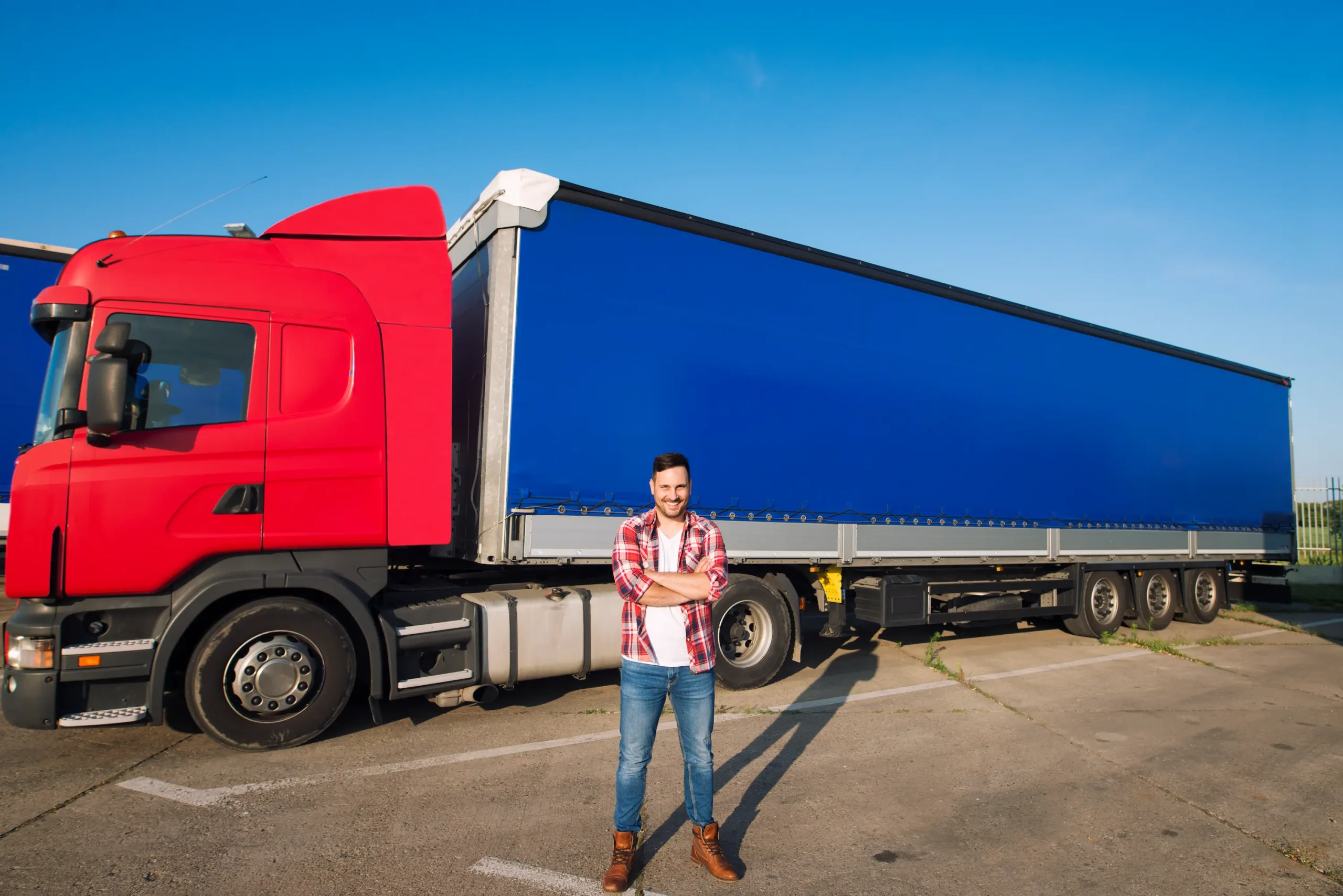 Less than truckload shipping Canada professional driver standing in front of semi-truck and trailer ready for regional freight delivery
