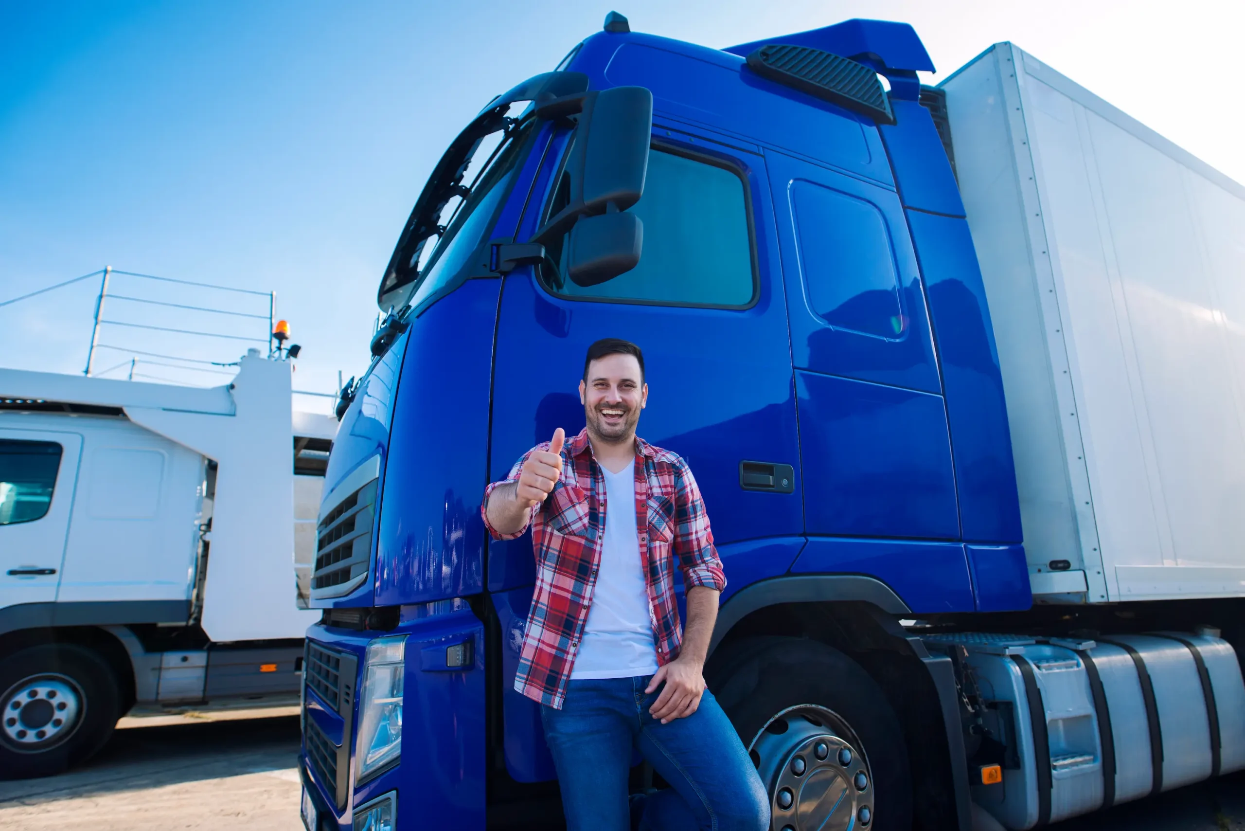 Less than truckload shipping Canada truck driver giving thumbs up beside commercial freight vehicle at logistics yard