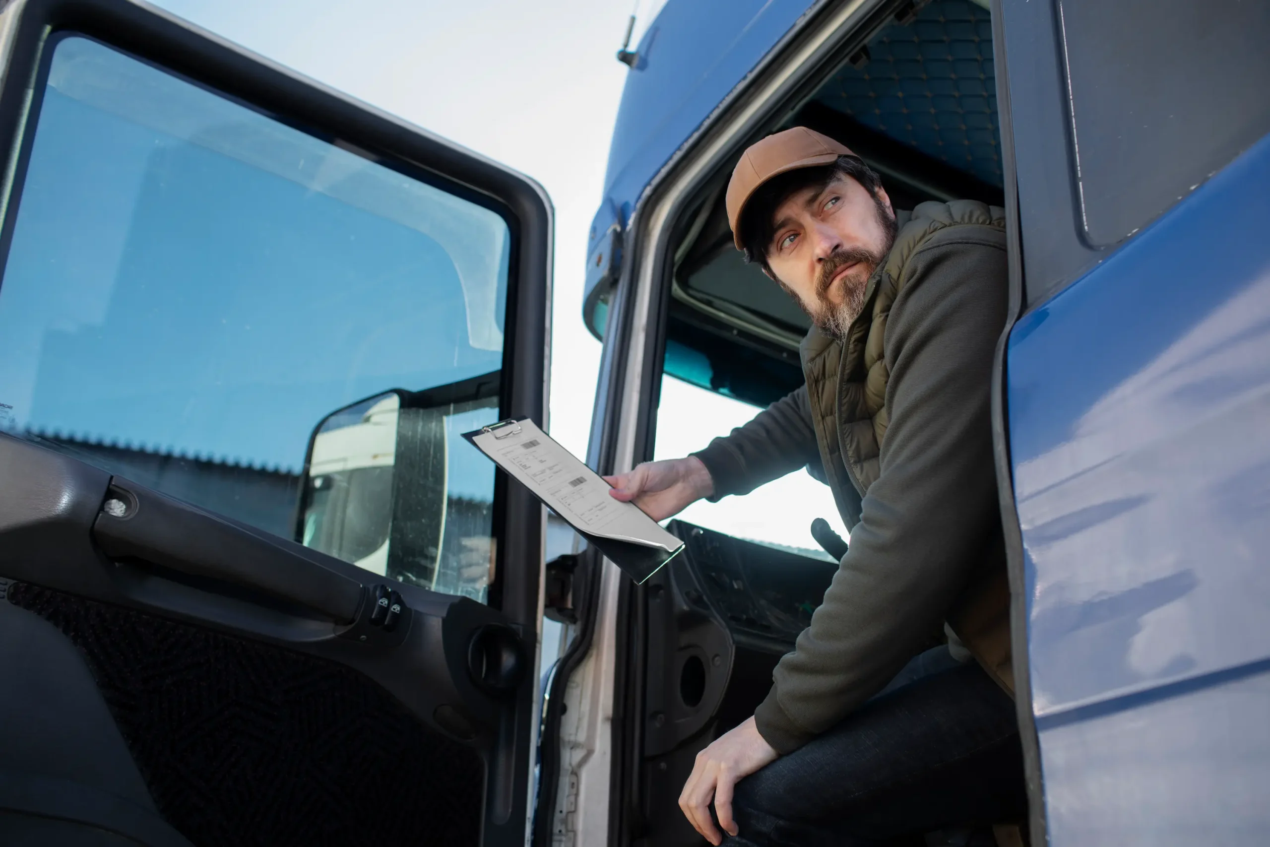 Truck driver reviewing shipment documents for Freight carrier services Western Canada ensuring accurate freight coordination