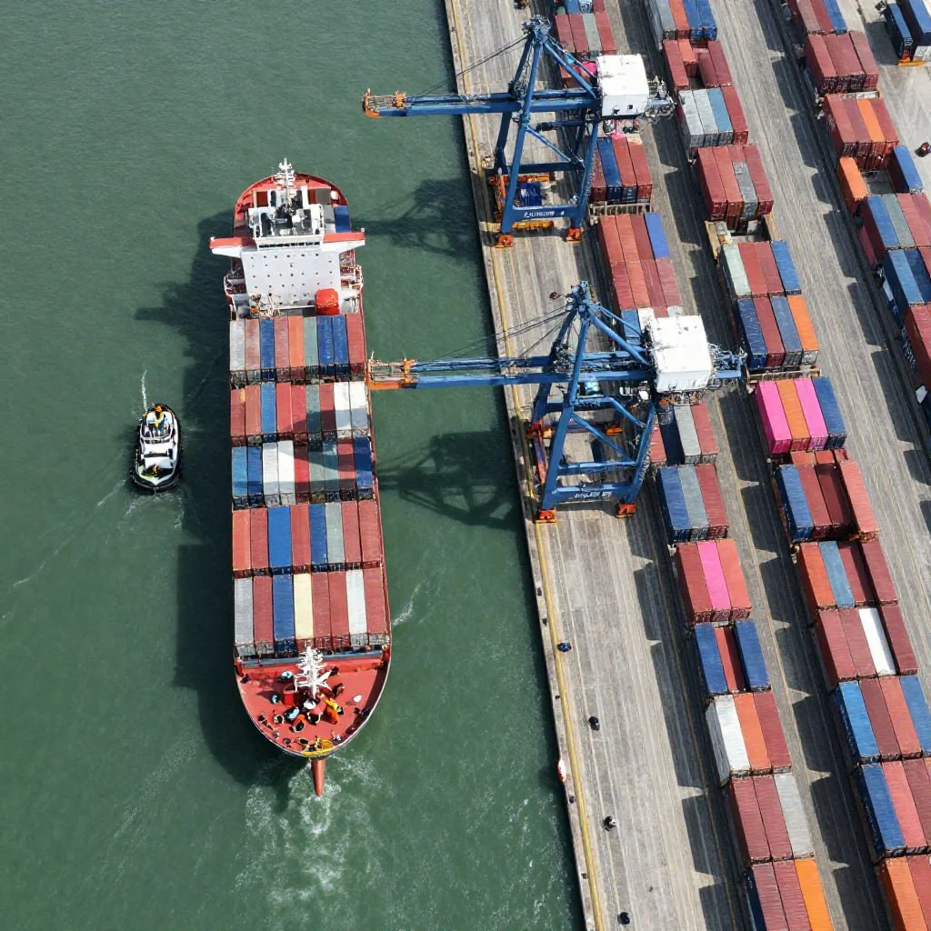 Container ship being loaded at port terminal representing global logistics connected to local shipping services near me for efficient freight movement
