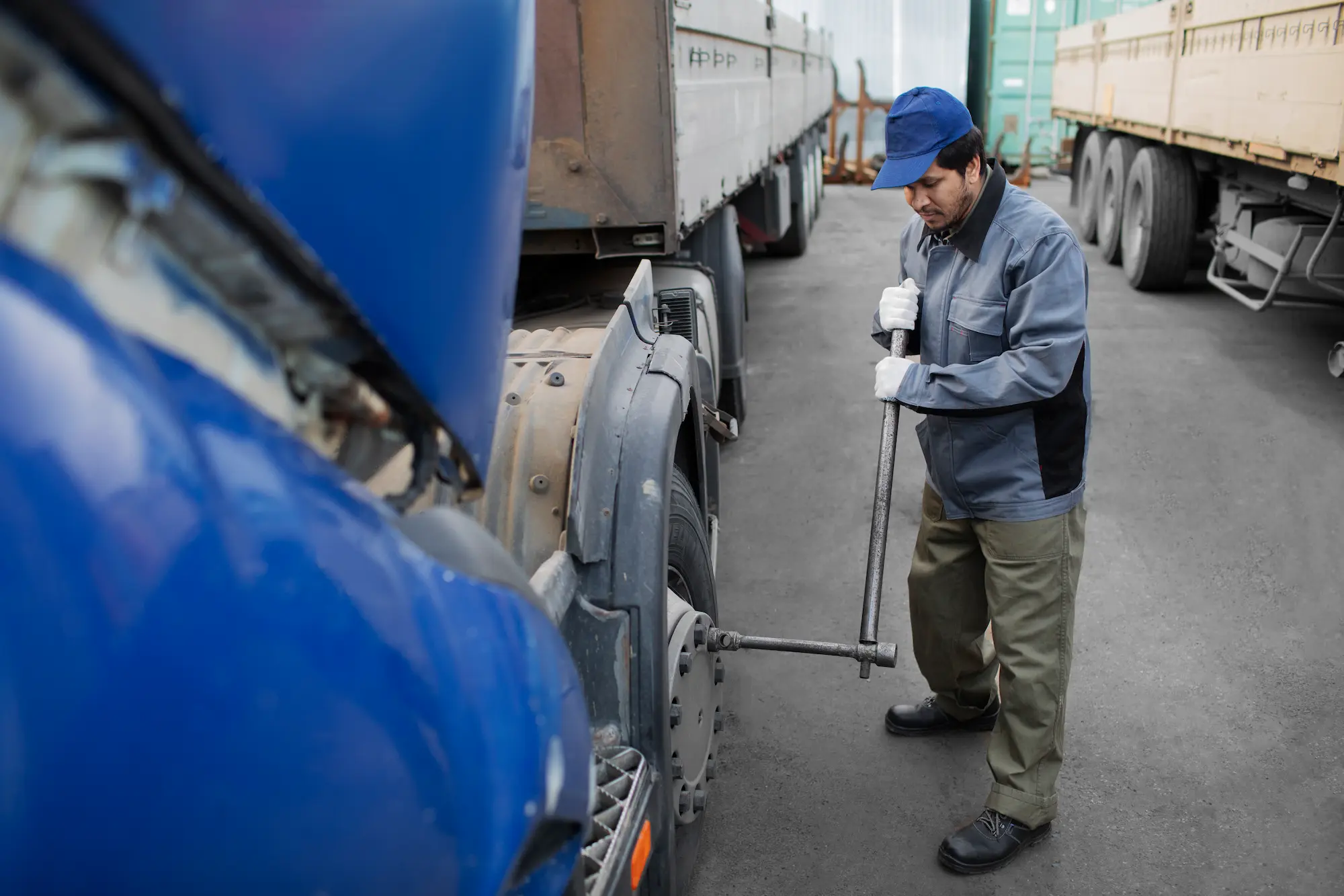 Truck driver performing maintenance on heavy vehicle representing professional hauling freight services and operational reliability