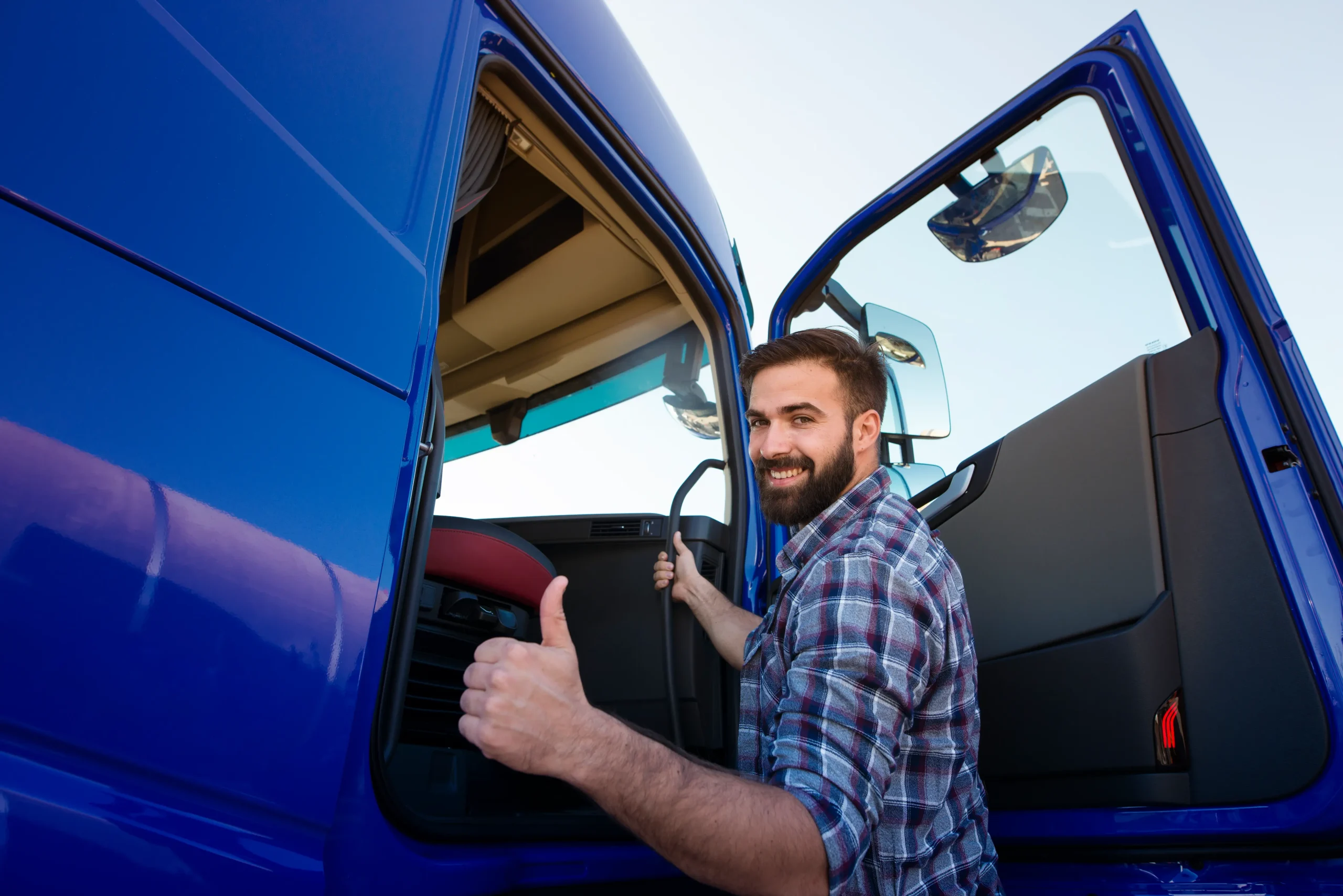 Commercial truck driver entering vehicle with thumbs up highlighting trusted Trucking companies in Vancouver BC transportation services