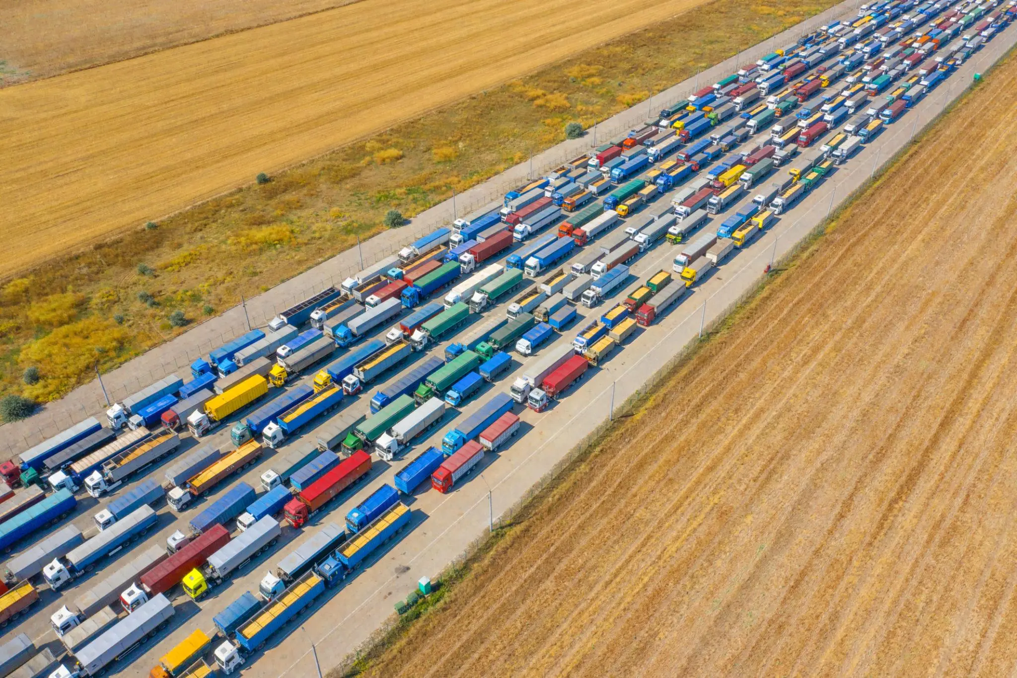 Aerial view of highway border crossing showing cross border shipping solutions and large-scale freight movement
