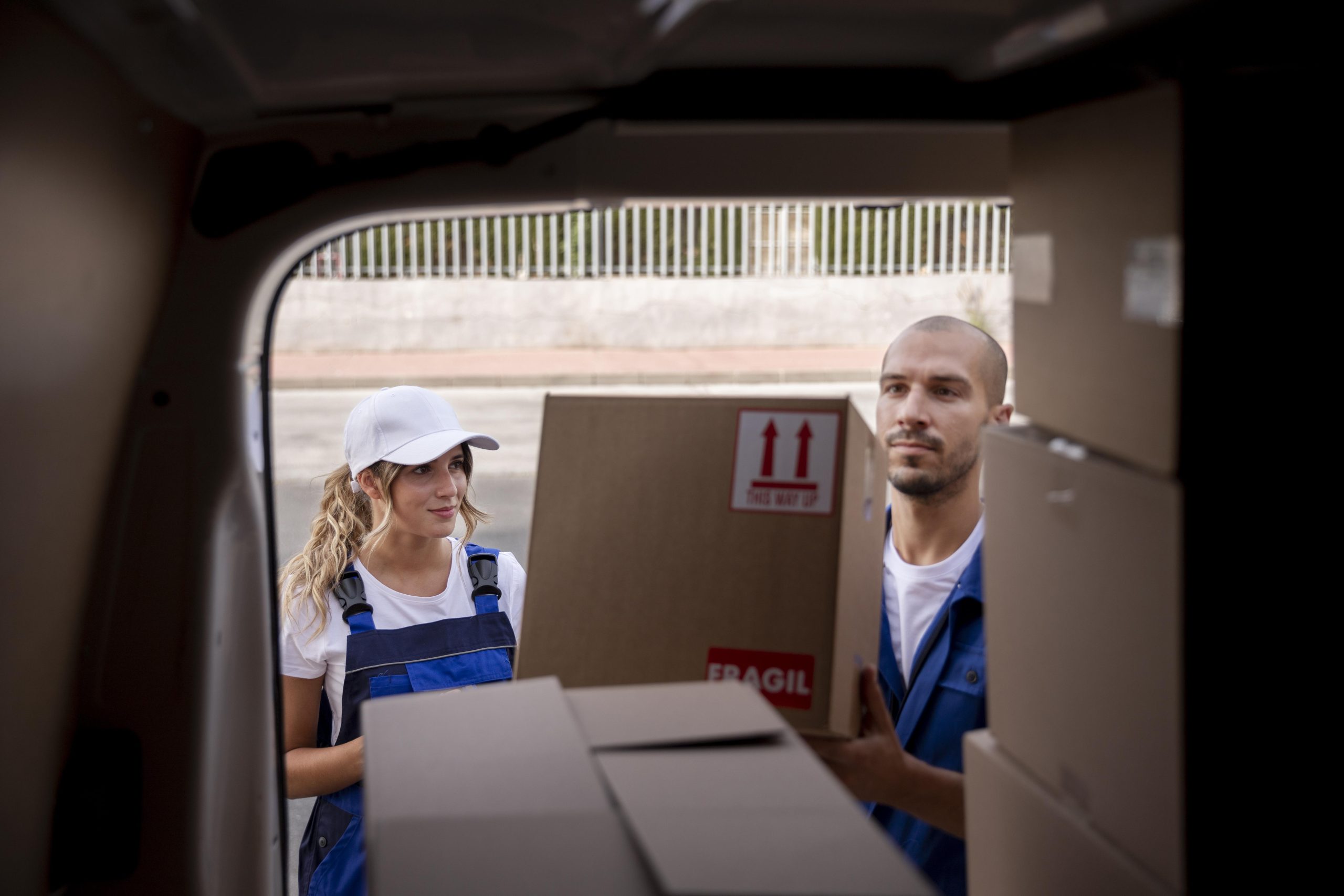 Team loading boxes inside delivery van representing reliable hauling company and structured freight handling process