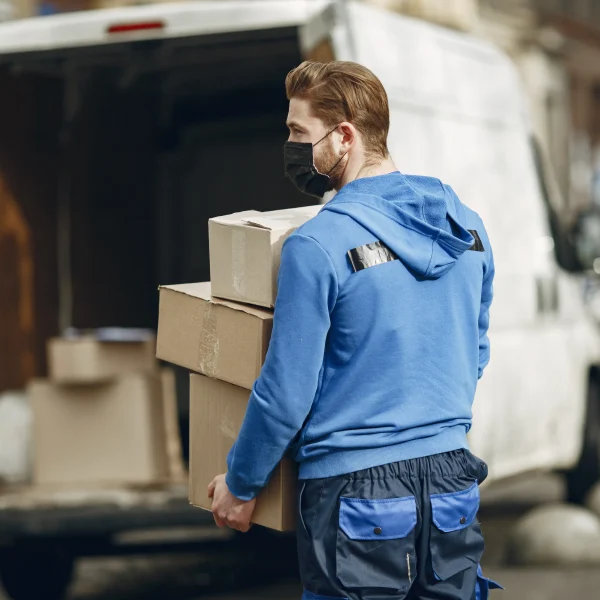 Delivery driver loading packages into van representing professional hauling company and efficient cargo handling services