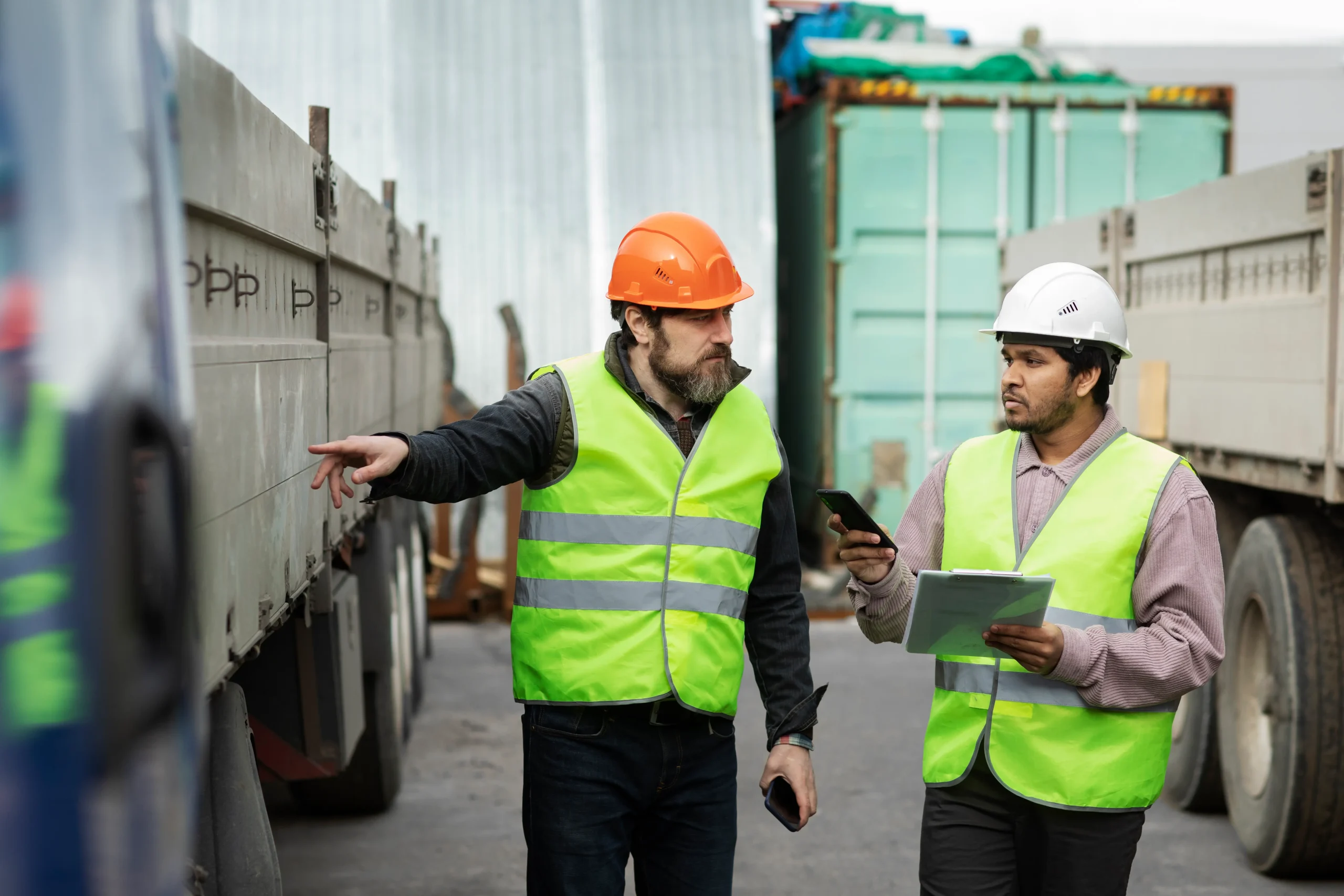 Logistics team discussing truck inspection for cross border transportation companies and freight coordination