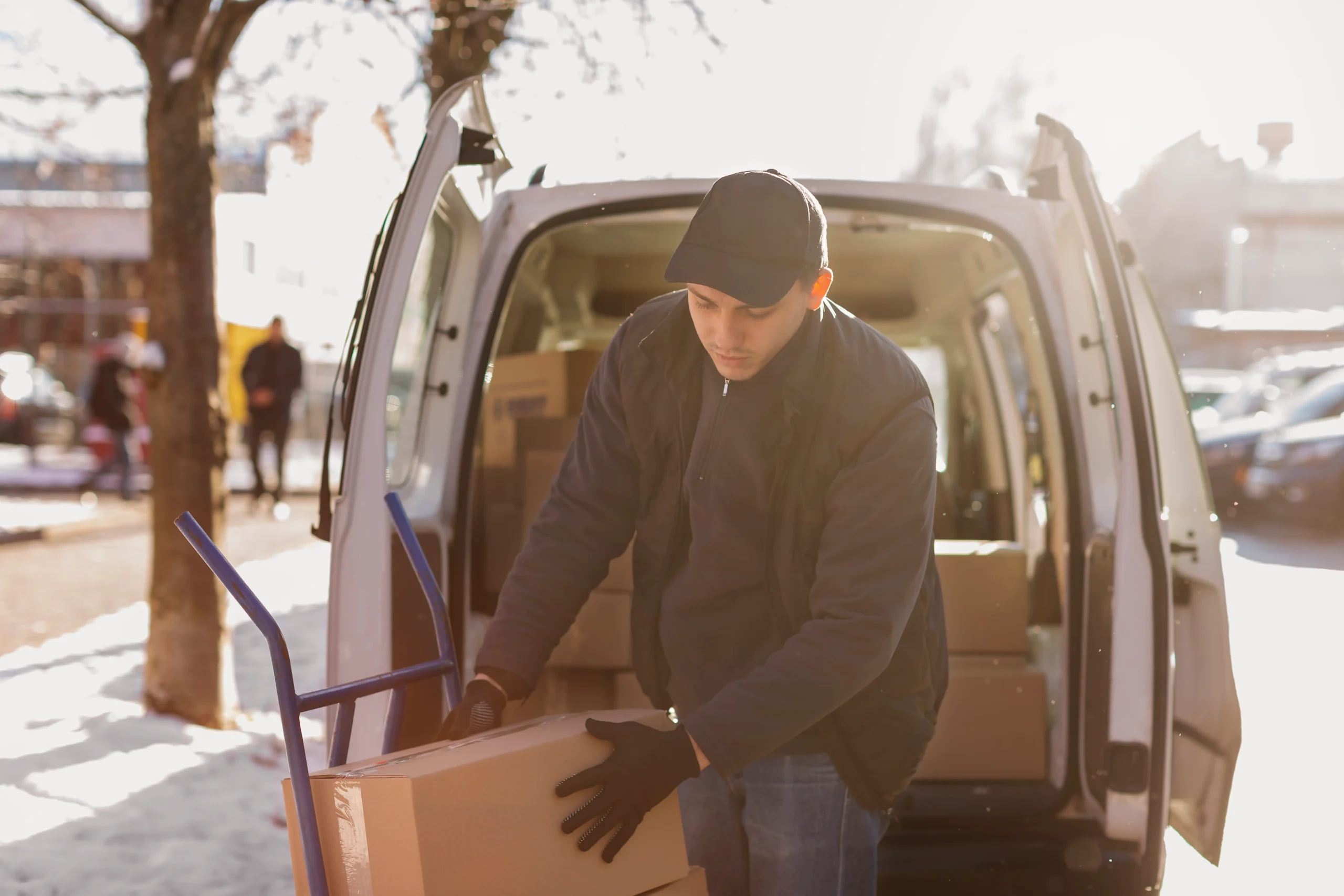 Local BC Transport Near Me delivery worker unloading commercial packages from a local transport van