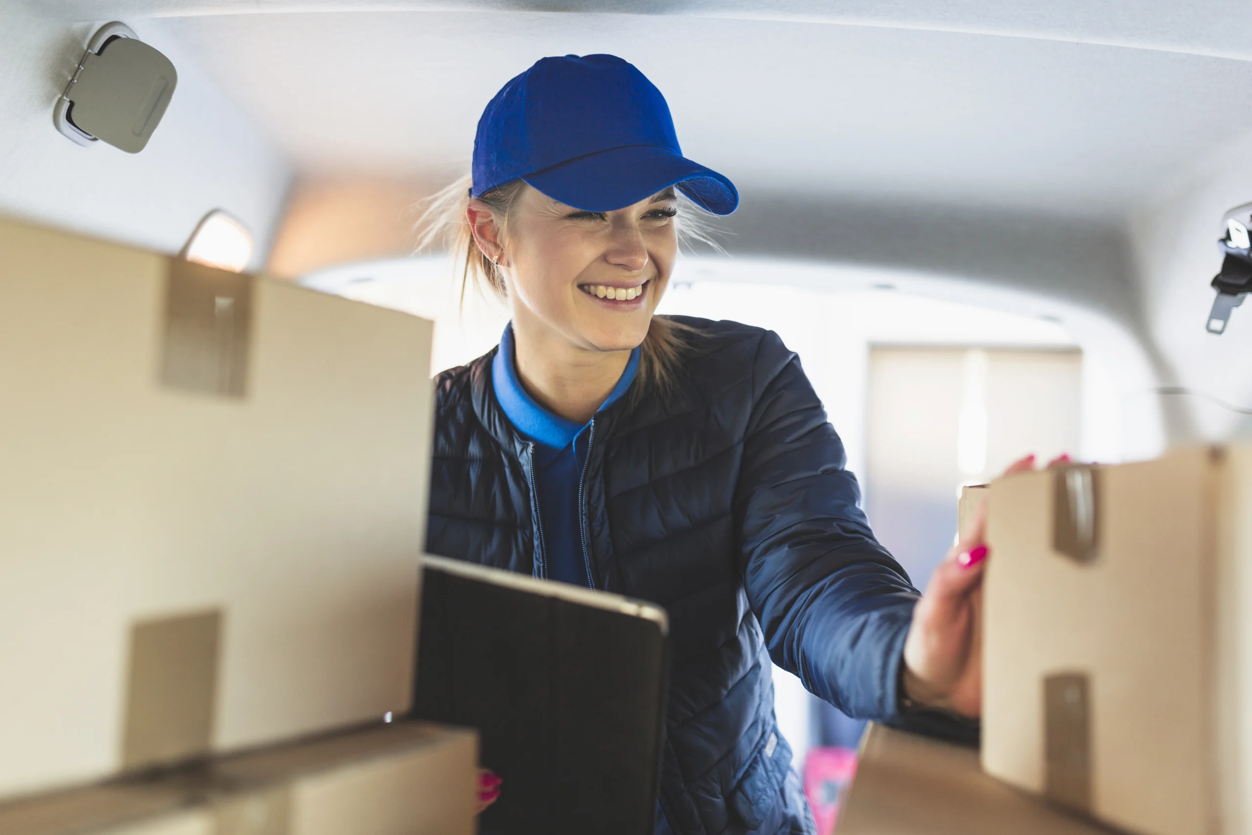 Trucking Operations & Dispatch Canada worker organizing packages and delivery documentation inside a transport vehicle