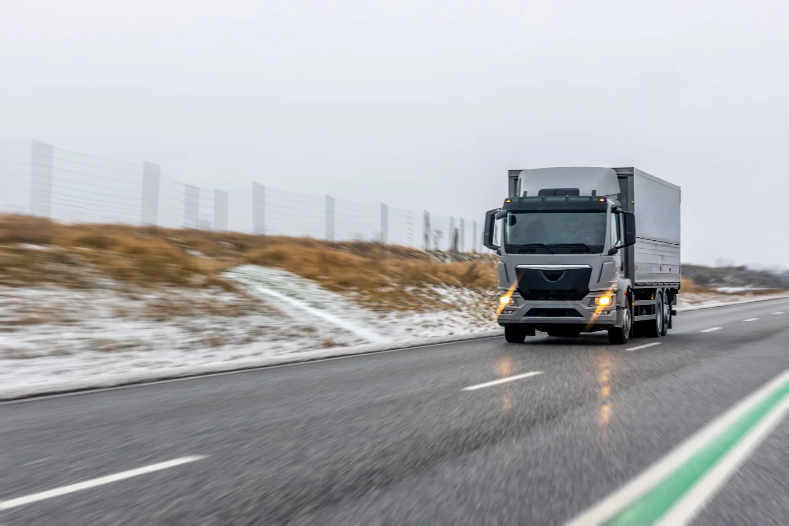 Medium-duty commercial truck transporting freight along a Canadian highway during winter conditions