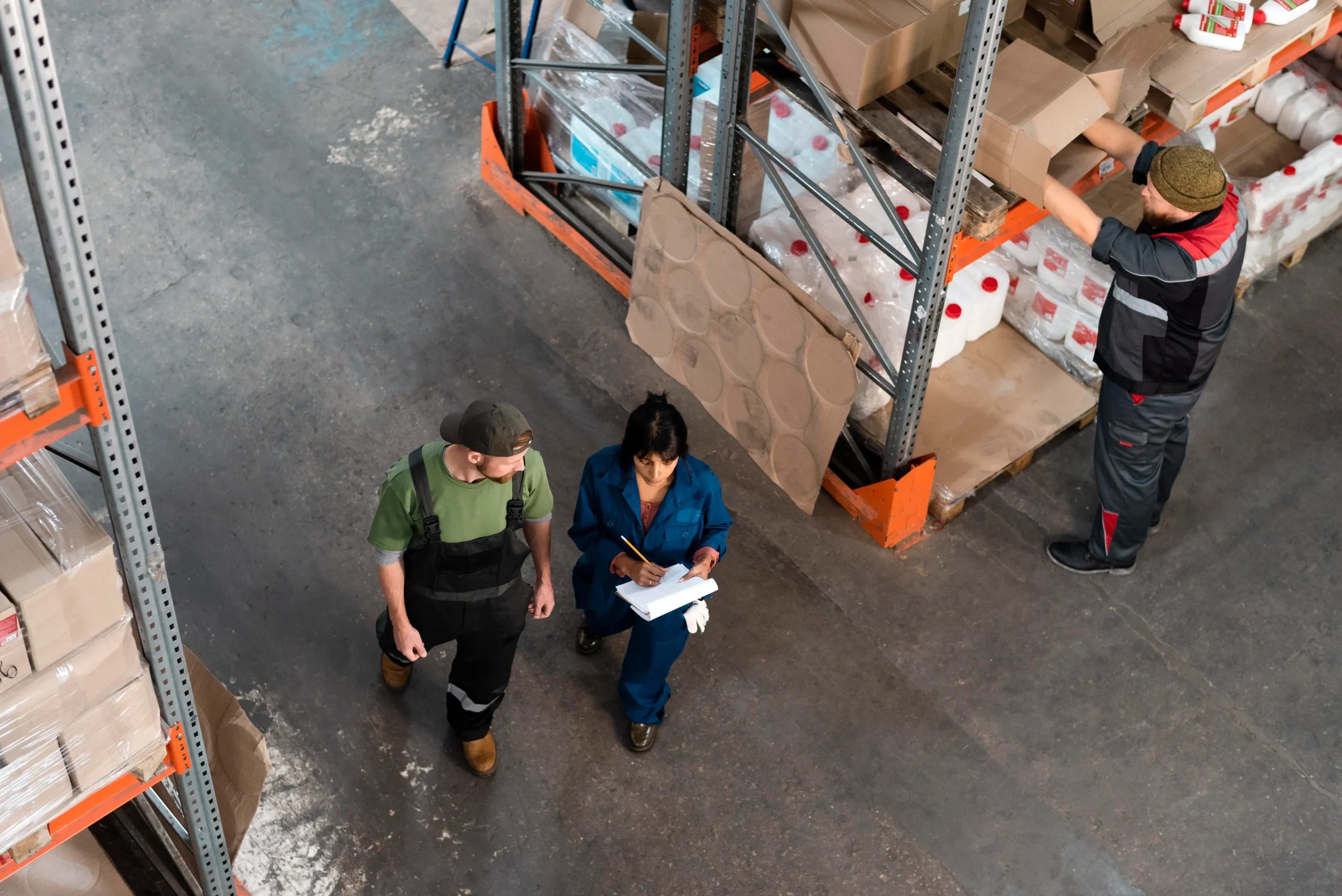 Warehouse supervisors conducting inventory checks and reviewing storage operations inside a Canadian distribution facility