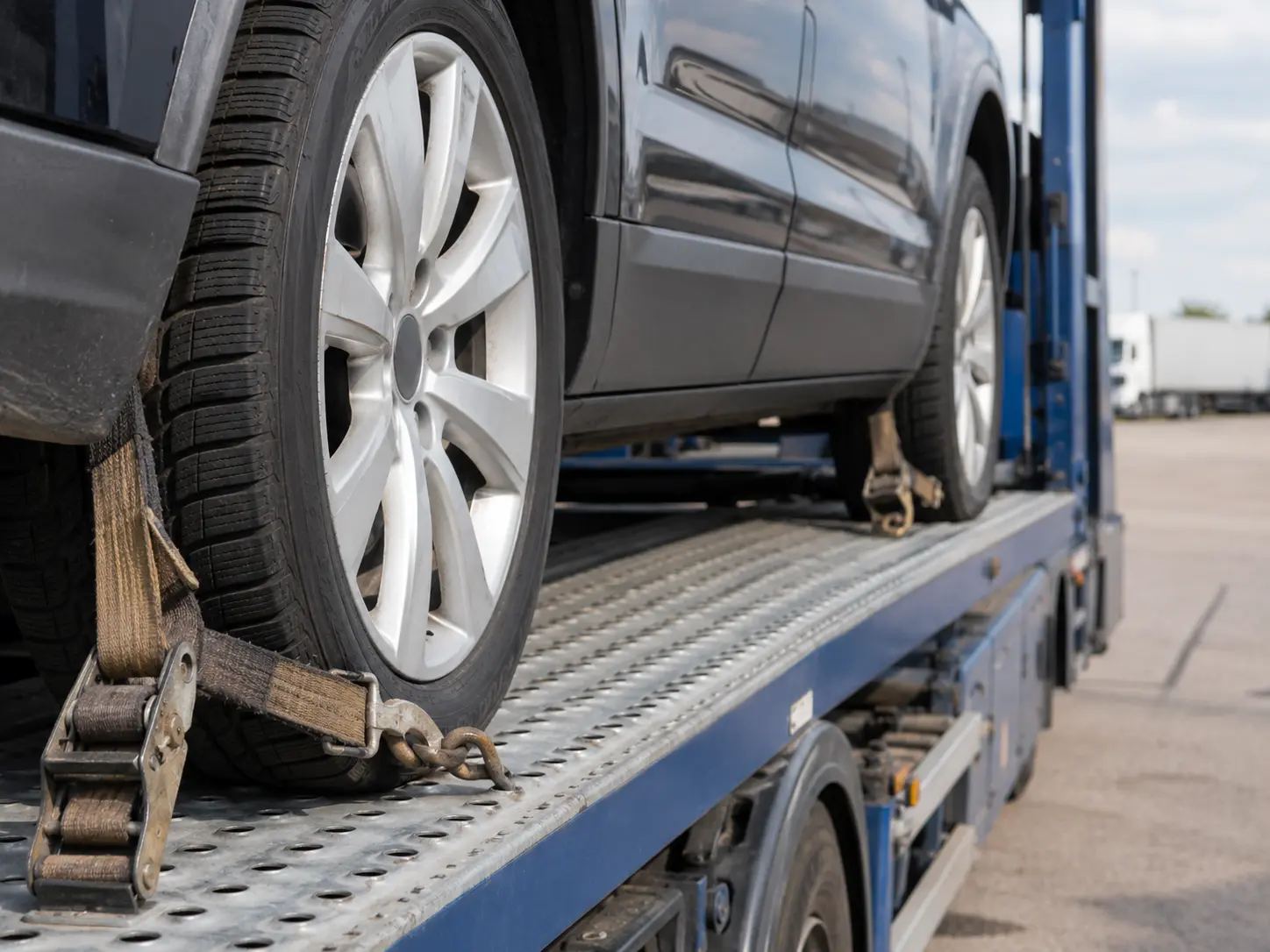 Vehicle wheel secured with transport strap on a Canada Car Transport carrier